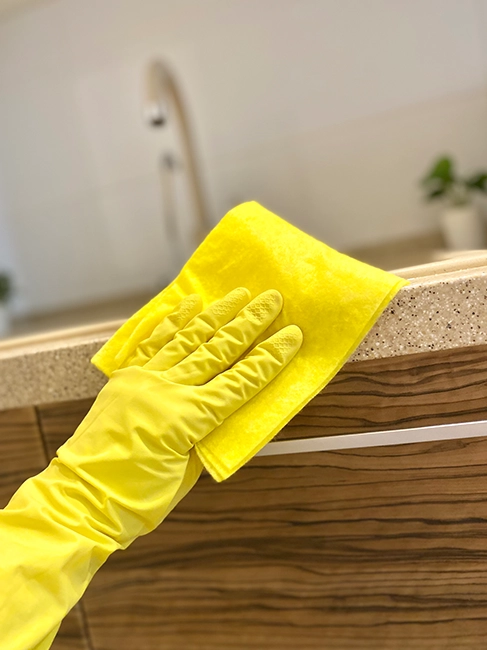 Cleaner making a bed with fresh white linens in tidy bedroom